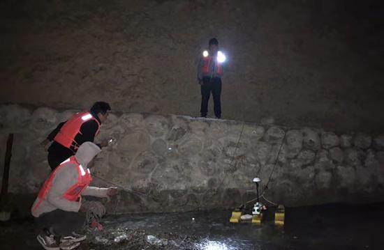 監測人員在夜間打著電筒工作。昌都市水文局圖