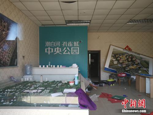 "從燕郊一家已經(jīng)關(guān)門的售樓處門外望進(jìn)去，地上散落著廢紙、條幅，沙盤上放著落灰的殺蟲劑。<a