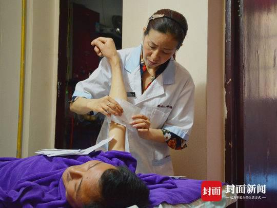 成興鳳在給顧客貼膏藥。丁偉 攝