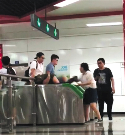 翻 兩男子用雙手撐住地鐵檢票閘機(jī)兩側(cè)，縱身翻過閘機(jī)口。視頻截圖