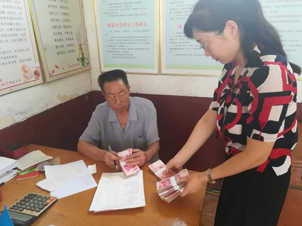 愛心企業工作人員（右）為田京榮一家送去捐款。