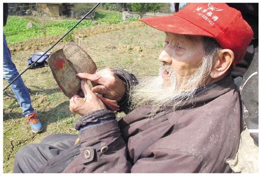 圖為陳大權老人和他保存的立功證。