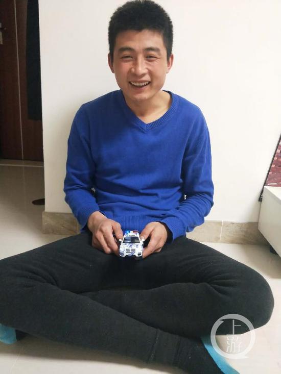 　1月22日，孫海達在大連哥哥的家中玩玩具警車，這是他最喜歡的玩具。攝影/張瑩