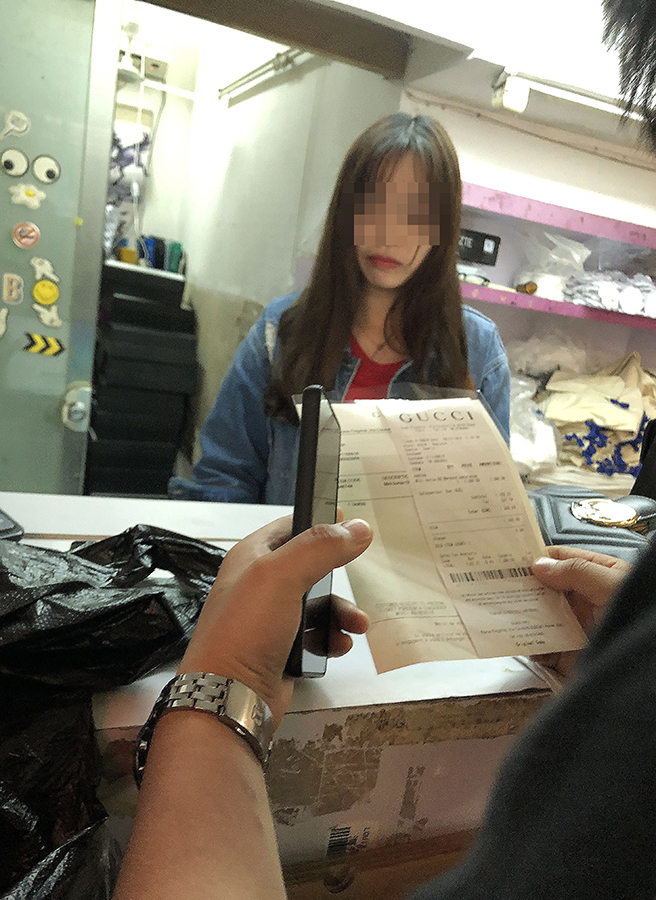 3月16日下午，廣州市白云世界皮具貿易中心旁桂花崗小區外商鋪，一處包裝店的工作人員給記者打印出了帶有某品牌標志的假冒的奢侈品銷售發票。 新京報記者 吳江 攝