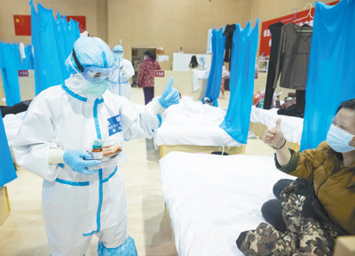 為緩解患者的焦慮情緒，在武漢大學中南醫院隔離病房，河北醫療隊護士用漫畫同患者交流。高翔攝（新華社發）