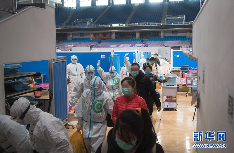 3月10日,武漢武昌方艙醫院正式休艙。這是醫護人員護送痊愈患者出艙。 新華社記者 肖藝九 攝