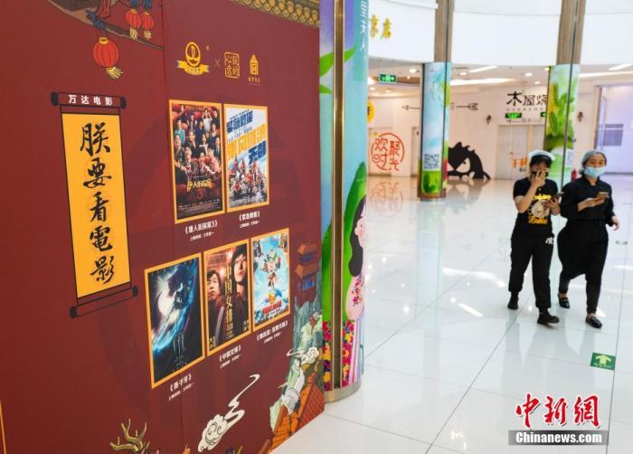 資料圖：2020年5月9日，行人從北京市朝陽區一家尚未恢復營業的電影院的宣傳板前經過。 中新社記者 侯宇 攝