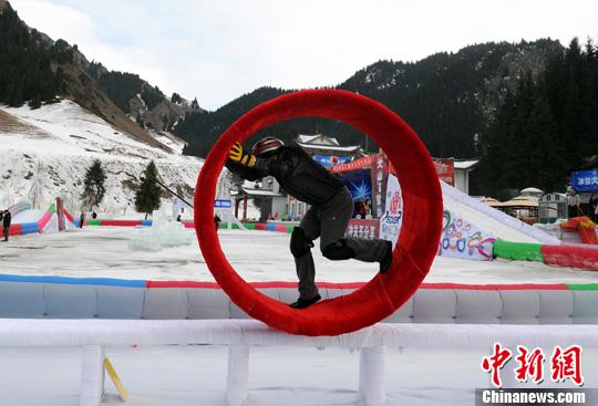 資料圖：12月29日，烏魯木齊第九屆絲綢之路冰雪風情節最大亮點“冰雪大沖關”，在天山大峽谷景區如期舉行。圖為一位市民正在挑戰冰上風火輪關卡。<a target='_blank'  data-cke-saved- ><p  align=